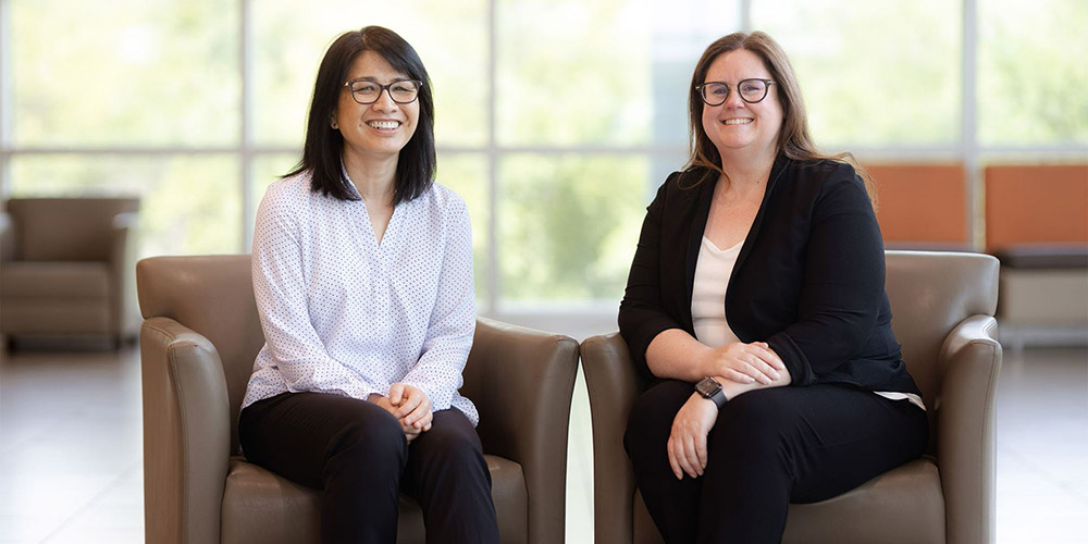 Dr. May Yuan (left) and Dr. Kristen Kennedy, seated in the Founders Building atrium.