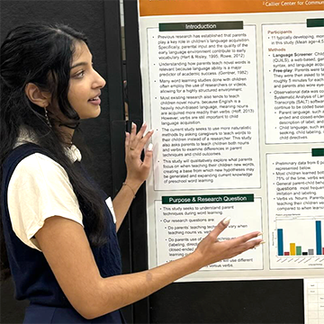 Student showing a poster from the SPUR Symposium