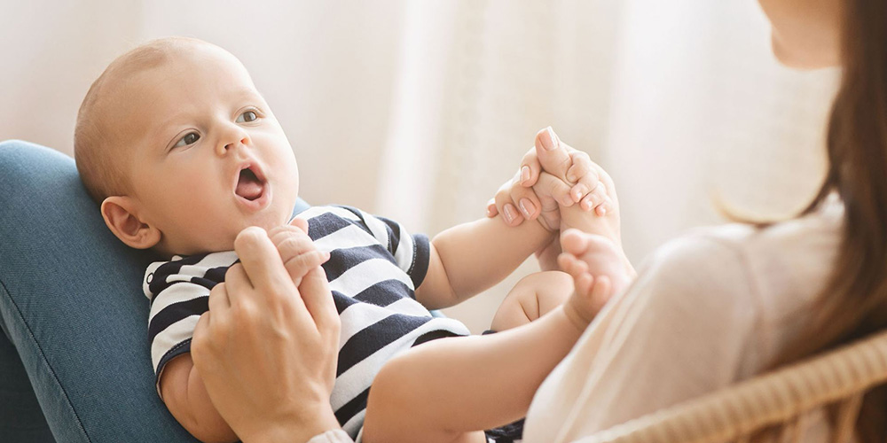 A mother plays with a baby